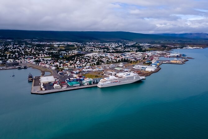Akureyri's harbour from above, a white cruise ship moored at the pier